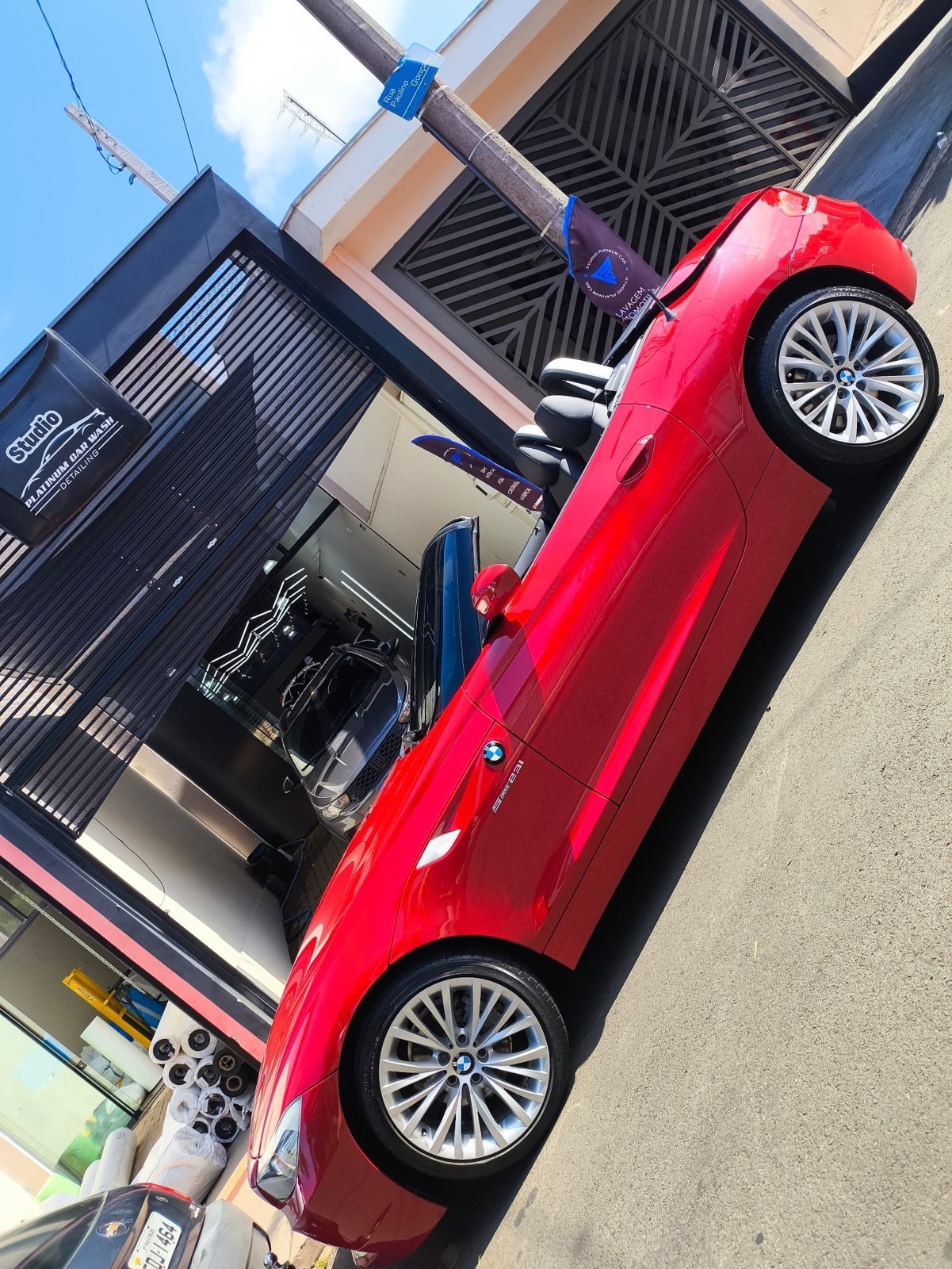 BMW vermelha pronta para entrega na frente do Studio Platinum Car